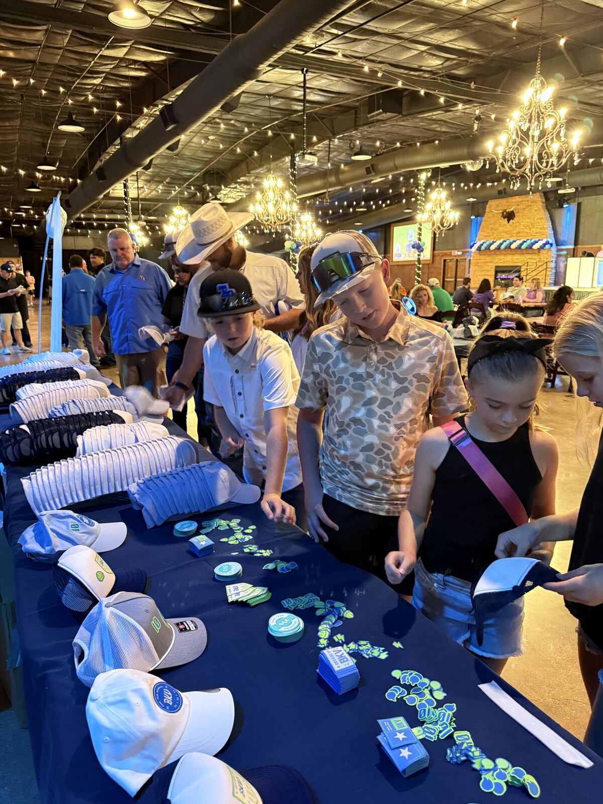Night event with attendees in printed apparel and merchandise under a decorated venue with ornamental displays