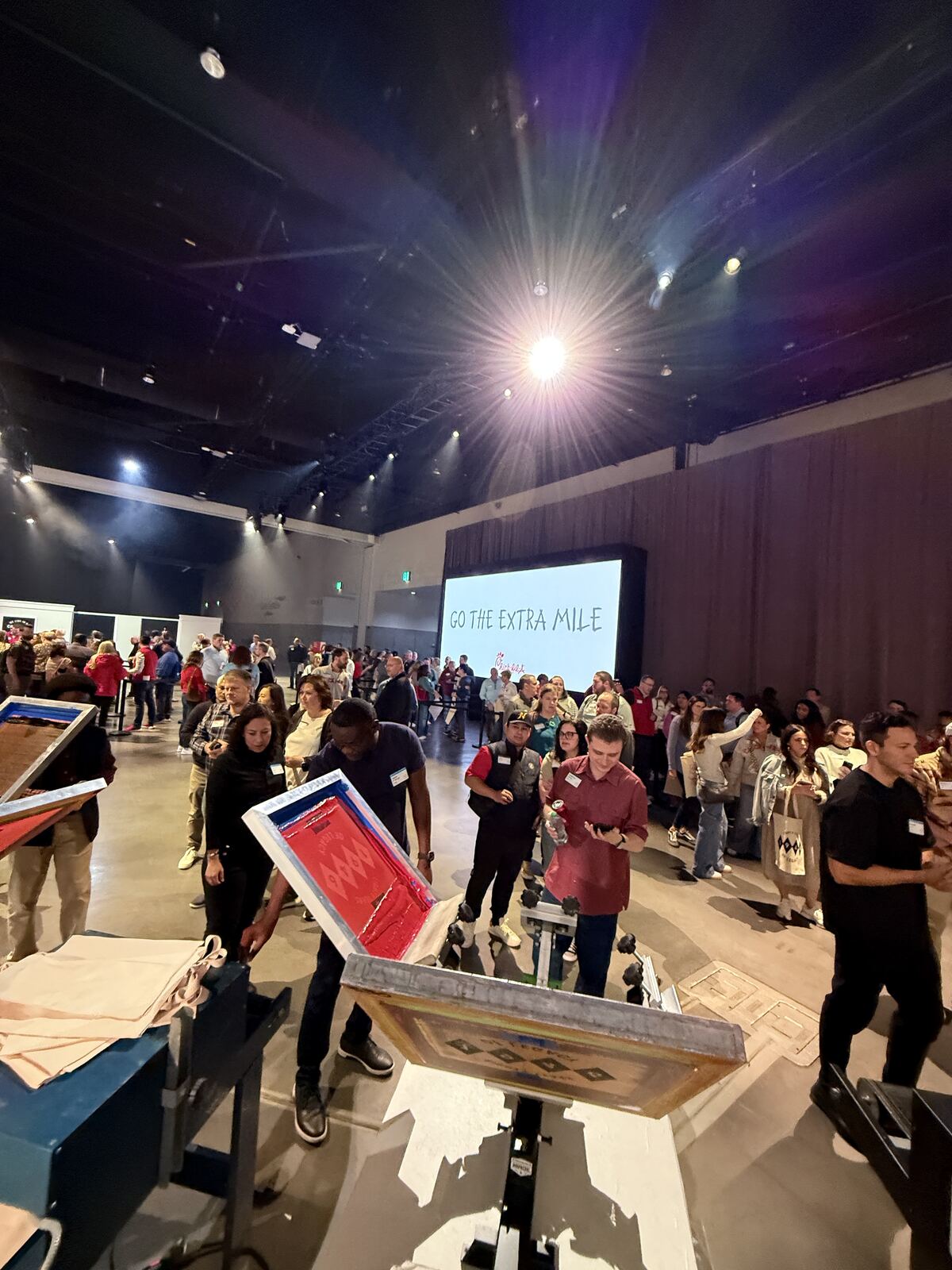 Crowds at an indoor event under stage lighting